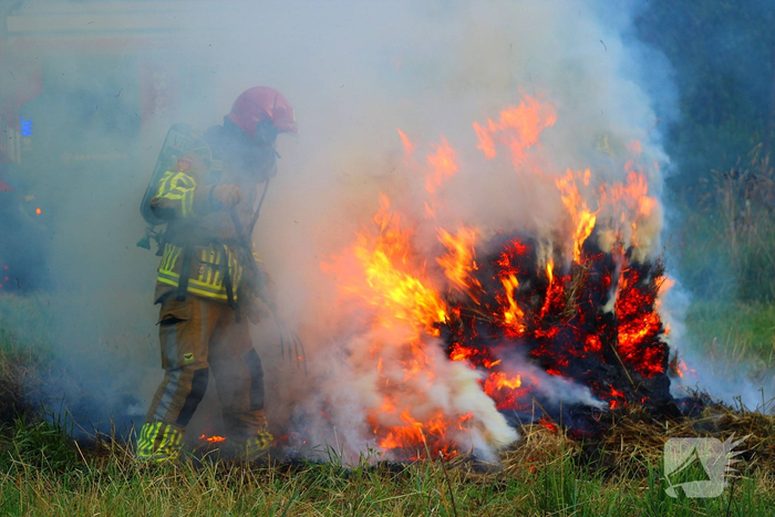 Brandweer blust brand in hooibaal