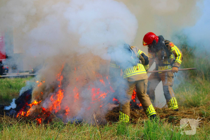 Brandweer blust brand in hooibaal