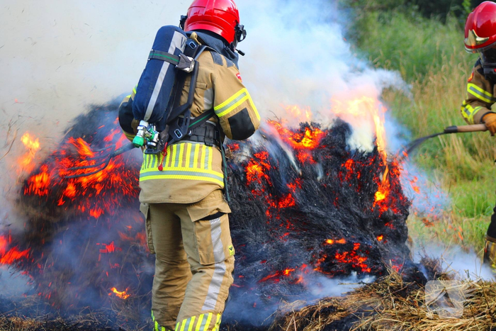 Brandweer blust brand in hooibaal