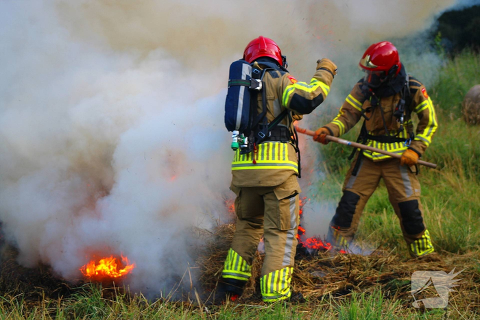 Brandweer blust brand in hooibaal