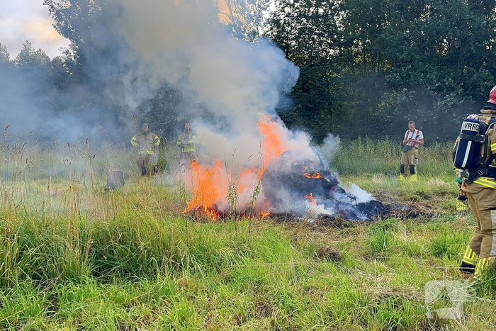 Brandweer blust brand in hooibaal