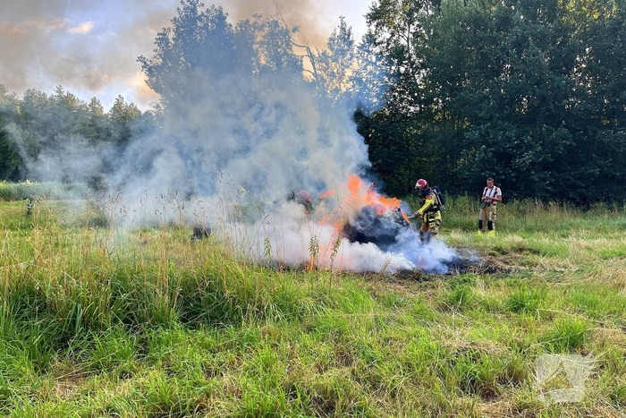 Brandweer blust brand in hooibaal