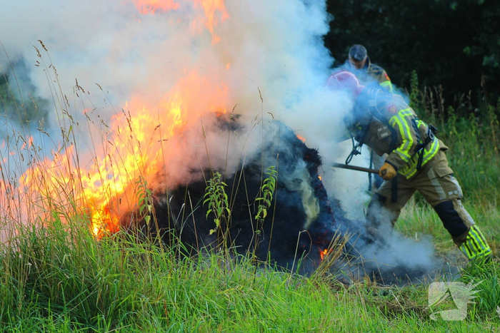 Brandweer blust brand in hooibaal