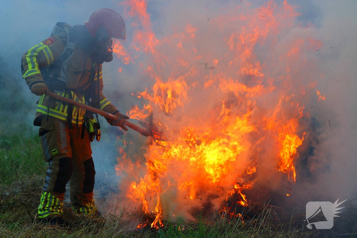 Brandweer blust brand in hooibaal