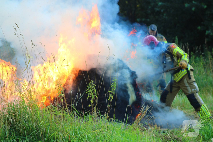 Brandweer blust brand in hooibaal