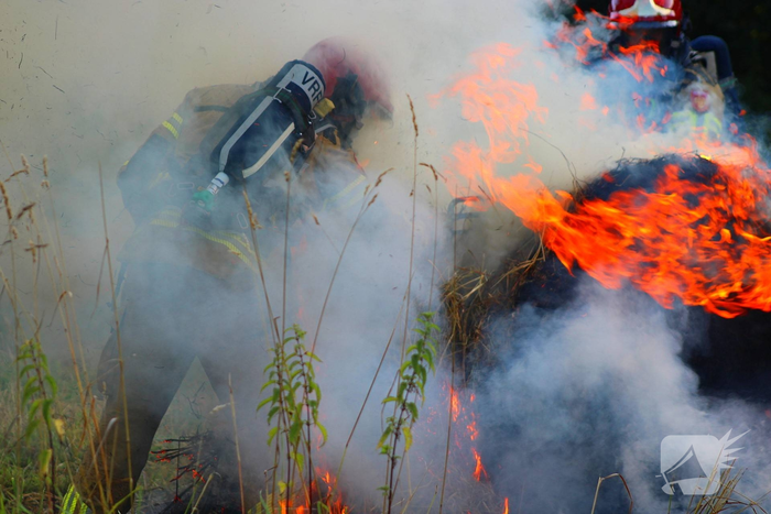 Brandweer blust brand in hooibaal