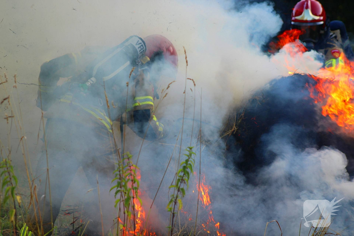 Brandweer blust brand in hooibaal