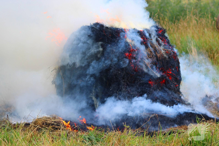 Brandweer blust brand in hooibaal