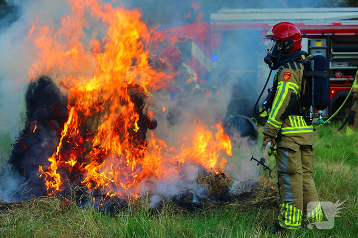 Brandweer blust brand in hooibaal
