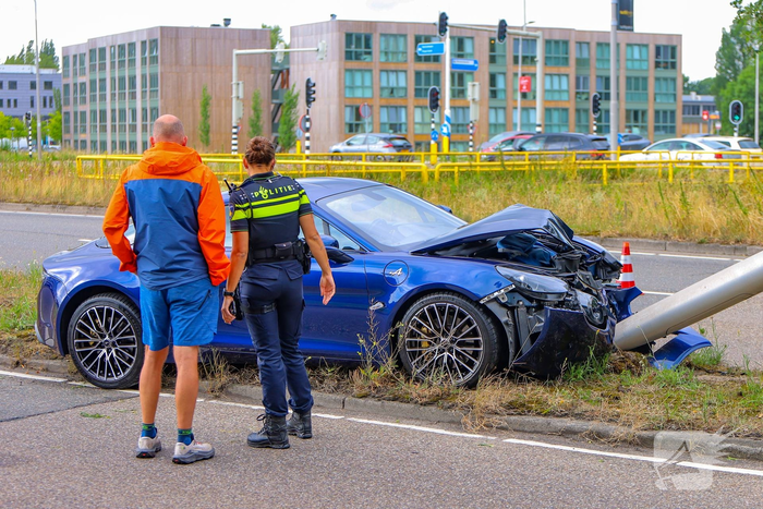 Sportwagen botst tegen lichtmast