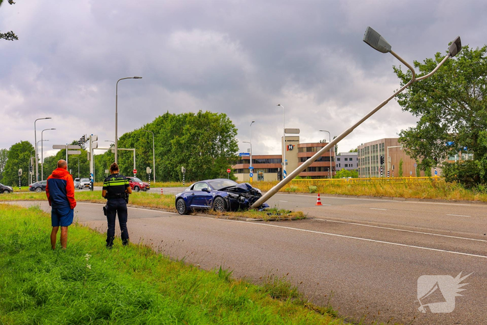 Sportwagen botst tegen lichtmast