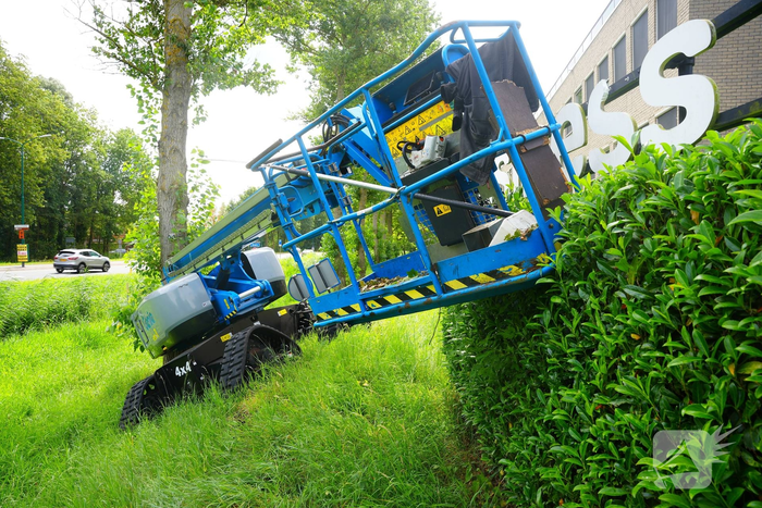 Hoogwerker komt in problemen naast bedrijfsgebouw