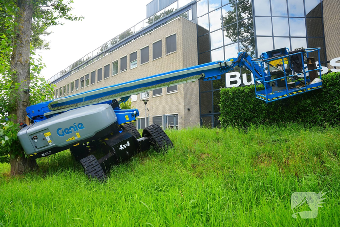 Hoogwerker komt in problemen naast bedrijfsgebouw