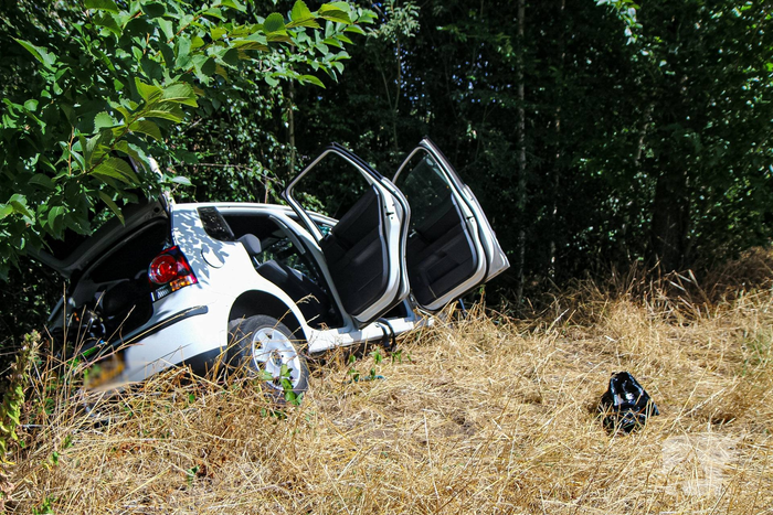 Auto botst door berm en hekwerk