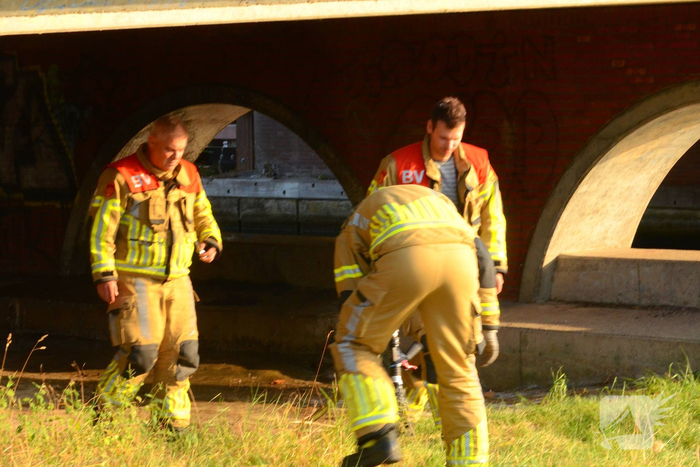Brandweer blust brand onder brug