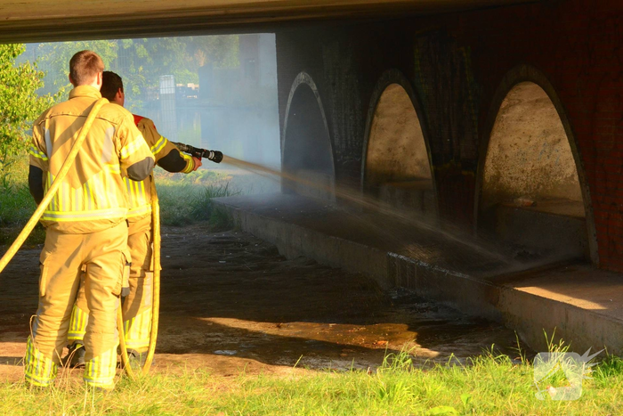 Brandweer blust brand onder brug