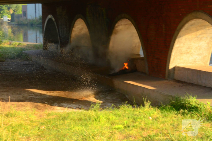Brandweer blust brand onder brug