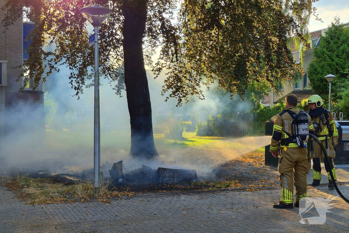 Brandweer blust brandend object tegen boom