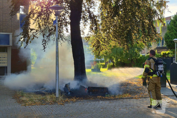 Brandweer blust brandend object tegen boom