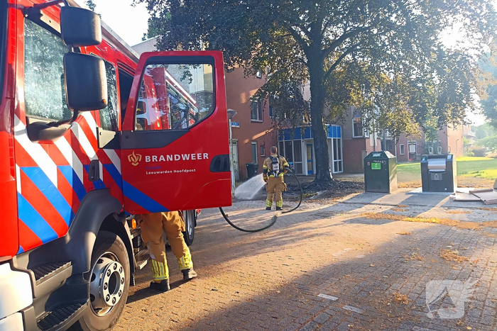 Brandweer blust brandend object tegen boom