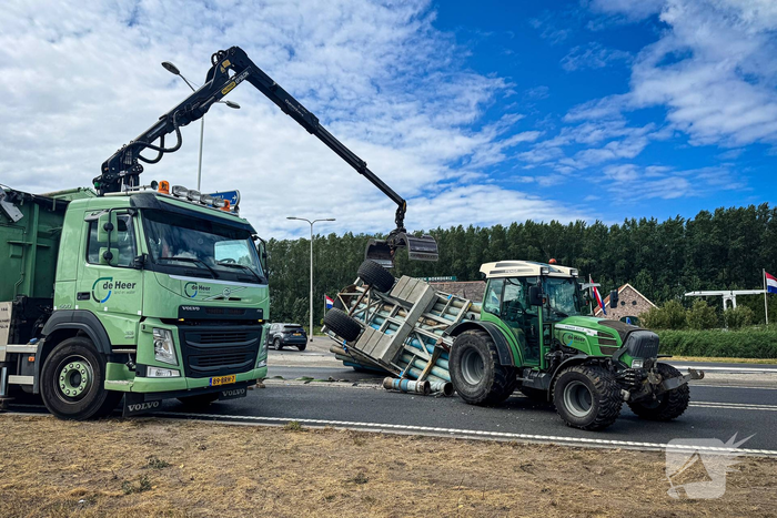 Aanhanger van tractor gekanteld op weg