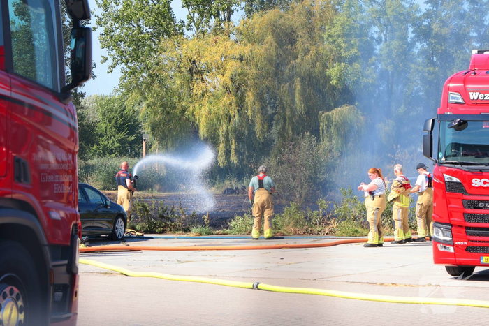 Groot stuk gras in brand naast transportbedrijf