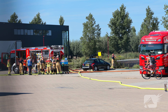 Groot stuk gras in brand naast transportbedrijf