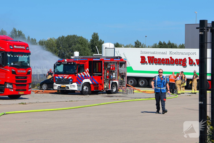 Groot stuk gras in brand naast transportbedrijf