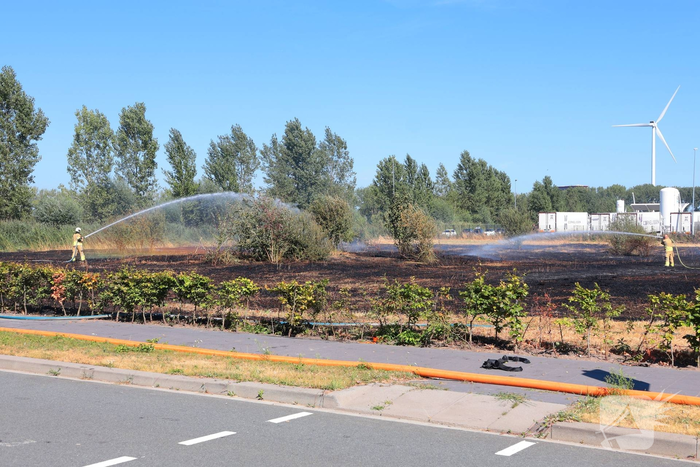 Groot stuk gras in brand naast transportbedrijf