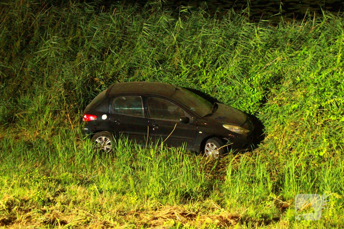 Auto raakt van dijk en belandt in riet