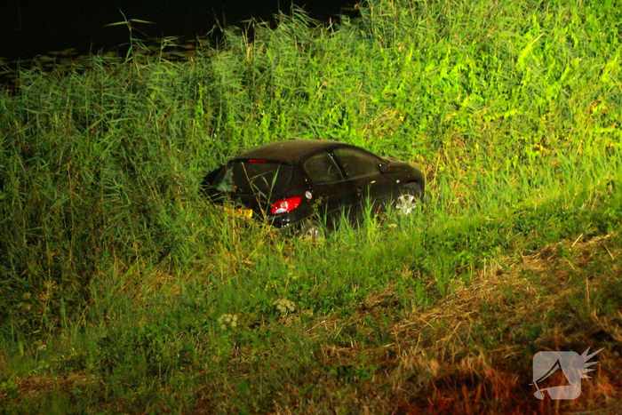 Auto raakt van dijk en belandt in riet