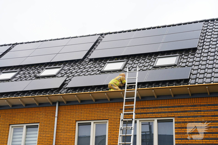 Kat vast onder zonnepanelen, brandweer in actie