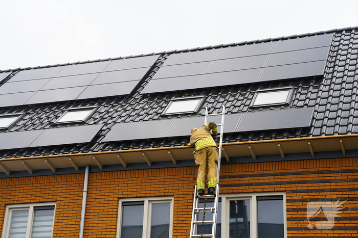 Kat vast onder zonnepanelen, brandweer in actie
