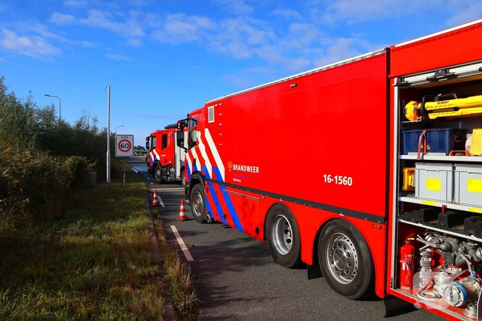 Grote afvalcontainer met huisvuil vat vlam tijdens rit