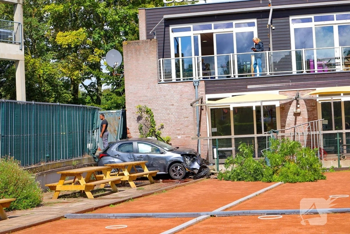 Auto rijdt speelplaats kinderdagverblijf binnen