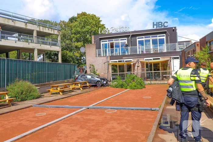 Auto rijdt speelplaats kinderdagverblijf binnen