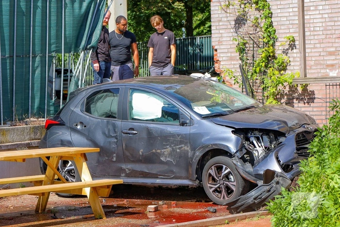 Auto rijdt speelplaats kinderdagverblijf binnen