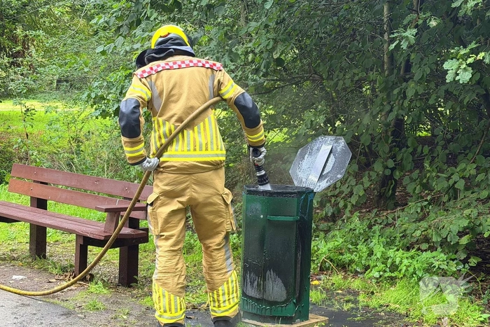 Brandweer blust brandende afvalbak
