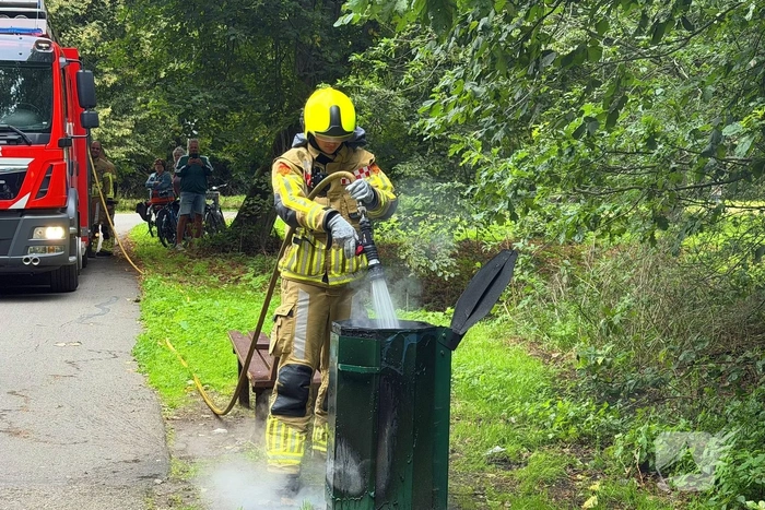 Brandweer blust brandende afvalbak