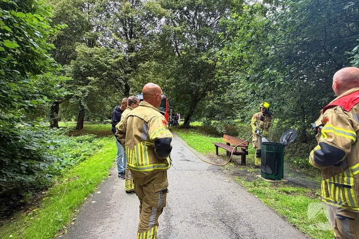 Brandweer blust brandende afvalbak