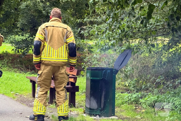 Brandweer blust brandende afvalbak