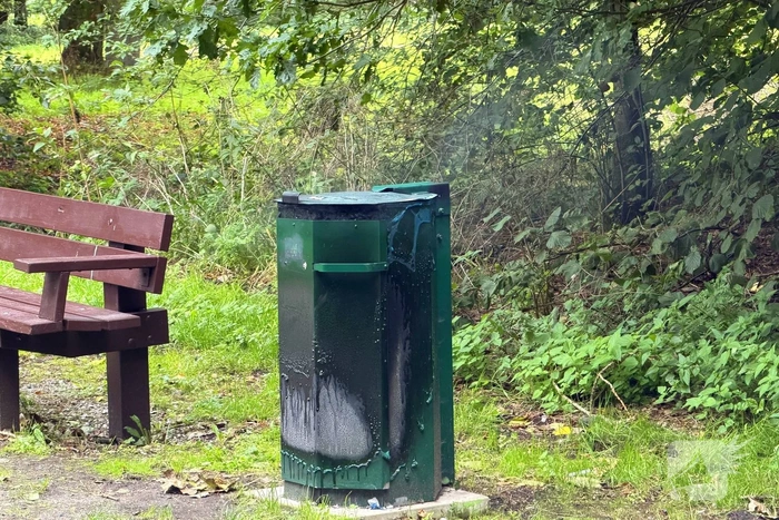 Brandweer blust brandende afvalbak