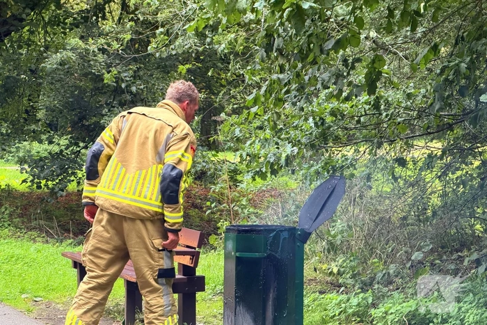 Brandweer blust brandende afvalbak