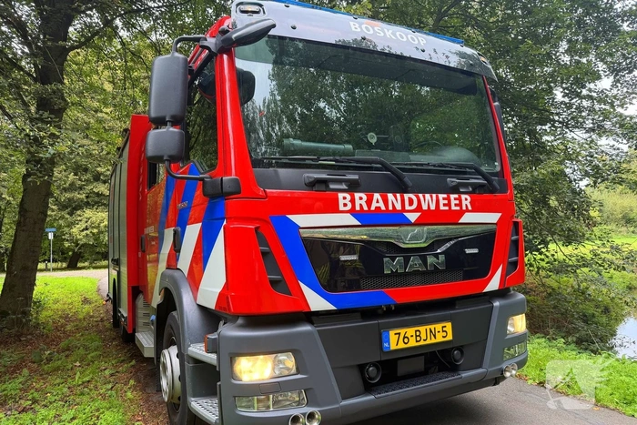 Brandweer blust brandende afvalbak