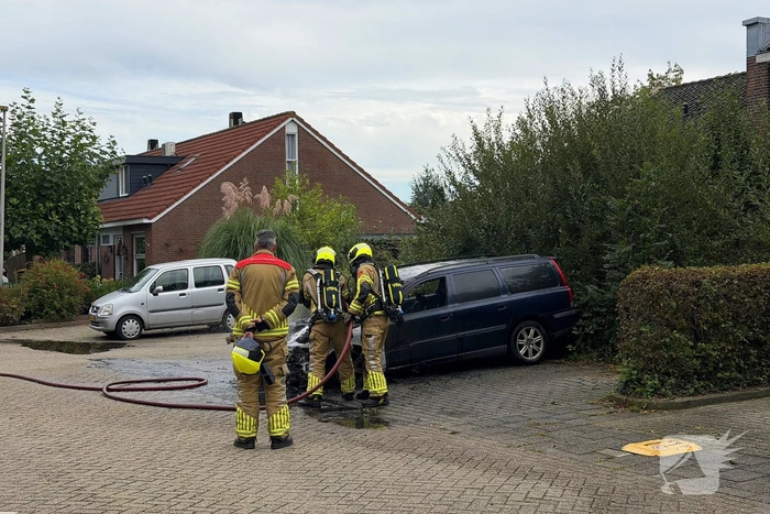 Brandweer blust brand in geparkeerde auto