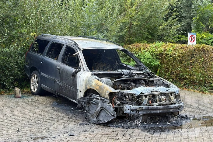 Brandweer blust brand in geparkeerde auto