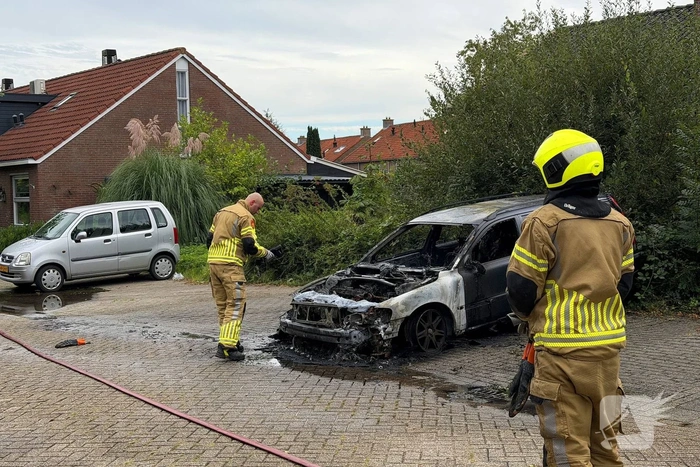 Brandweer blust brand in geparkeerde auto