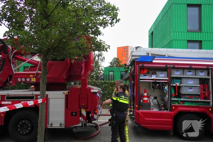 Isolatiemateriaal in houten wand van hoekwoning in brand