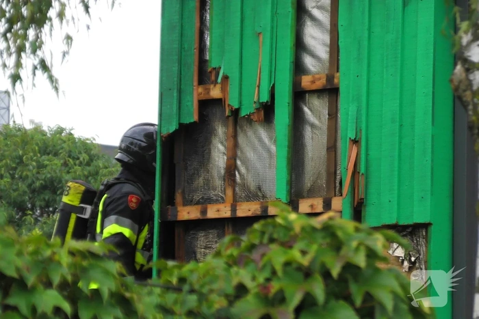 Isolatiemateriaal in houten wand van hoekwoning in brand