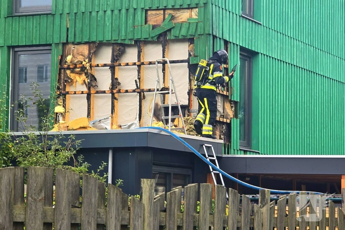 Isolatiemateriaal in houten wand van hoekwoning in brand